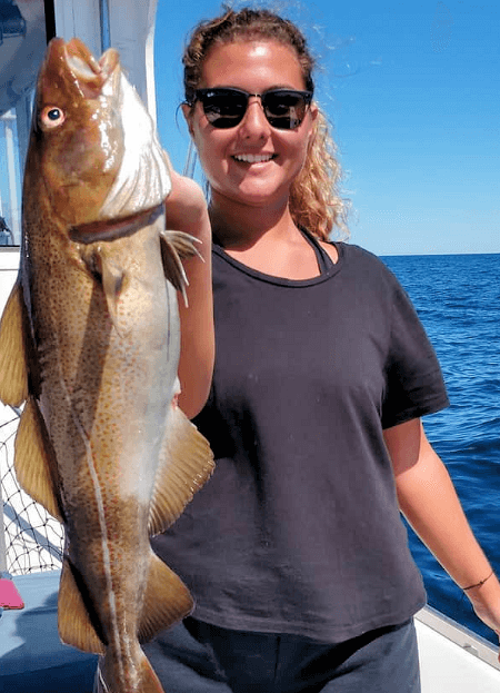 Lady angler show off the cod she caught on Fish Trap.